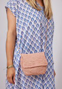 Small pink straw crossbody bag on model