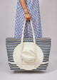 Model holding white and navy striped traveler tote