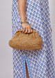 Model holding brown straw slouchy clutch