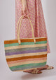 Model holding straw tote with multi colored stripes