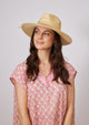 Model wearing straw hat with tan leather detail