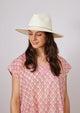 Model wearing a white sun hat and pink kaftan