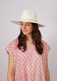 Model wearing a white sun hat and pink kaftan