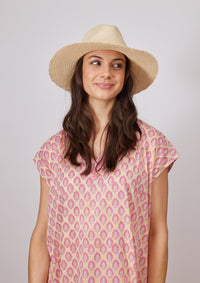 Model looking to her left wearing fringed straw hat