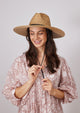 Model wearing straw hat with black trim and chinstrap