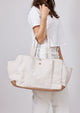 Model holding white tote with pockets on arm