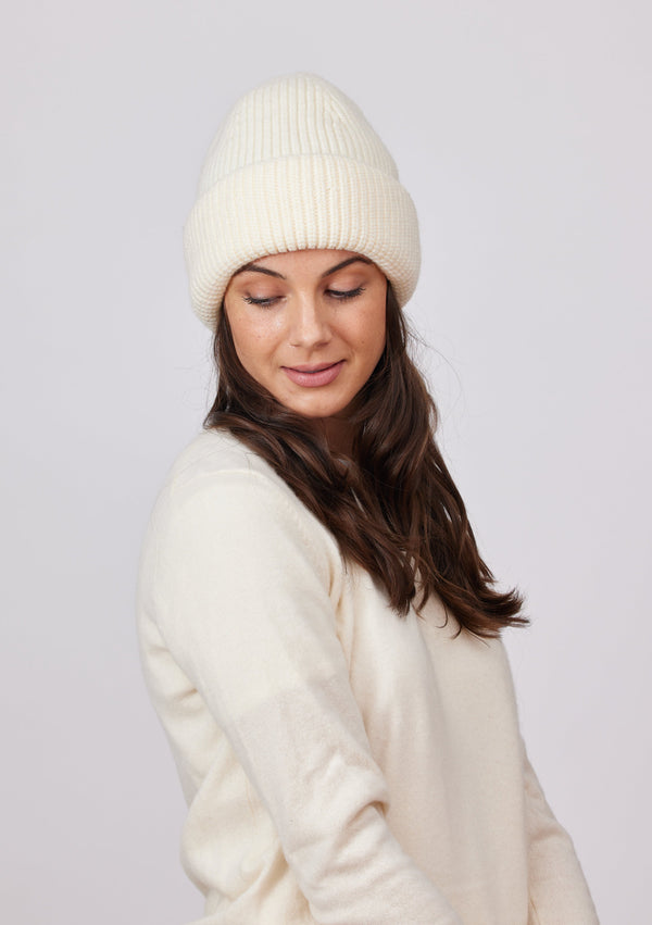 Model wearing ivory cuffed knit beanie