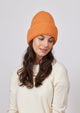 Model wearing orange knit cuff beanie