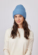Model wearing denim blue cuffed knit beanie