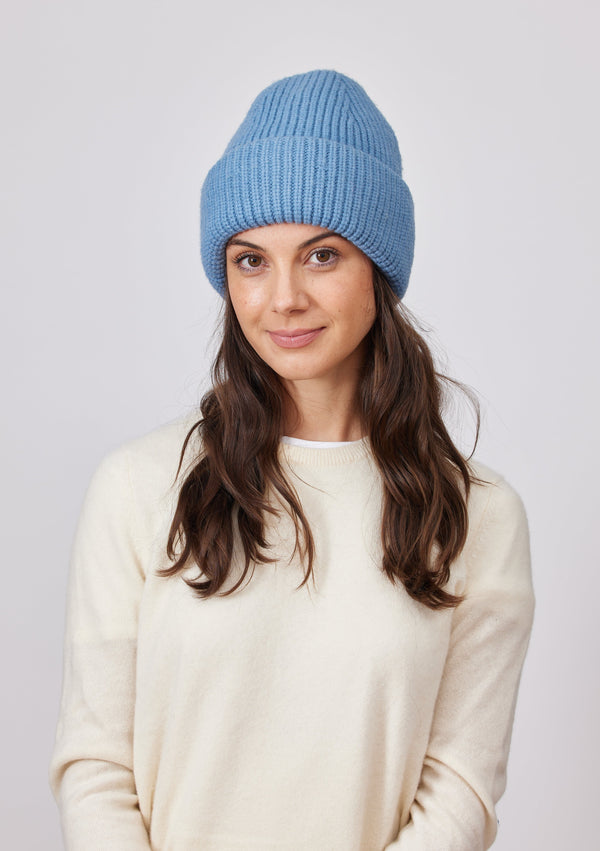 Model wearing blue cuffed knit beanie