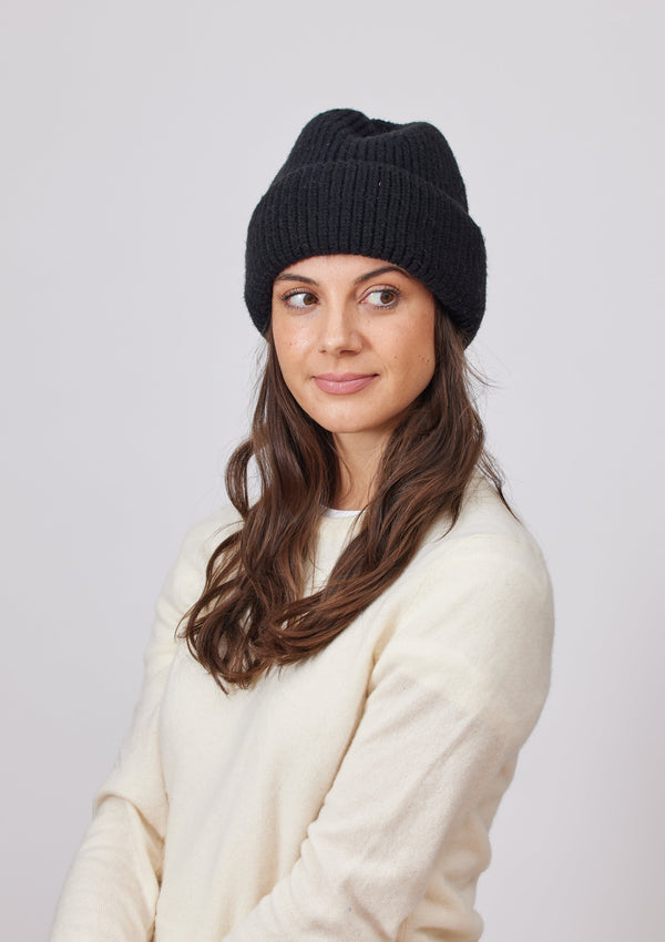 Model wearing a black knit cuffed beanie