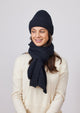 Model wearing black ribbed knit beanie, scarf and ivory sweater