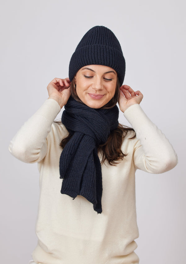 Model wearing black ribbed knit beanie and black scarf