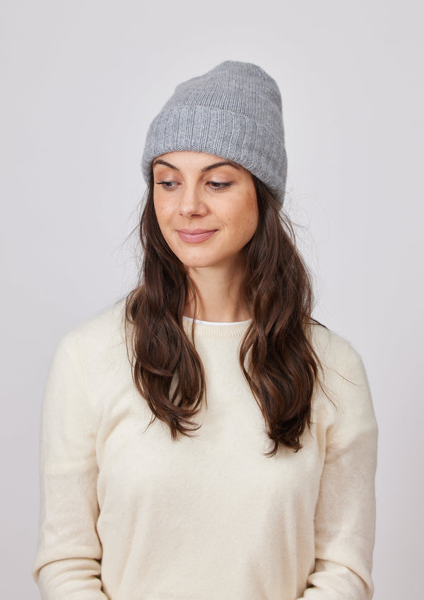 Grey slouchy cashmere beanie on model looking down to her right