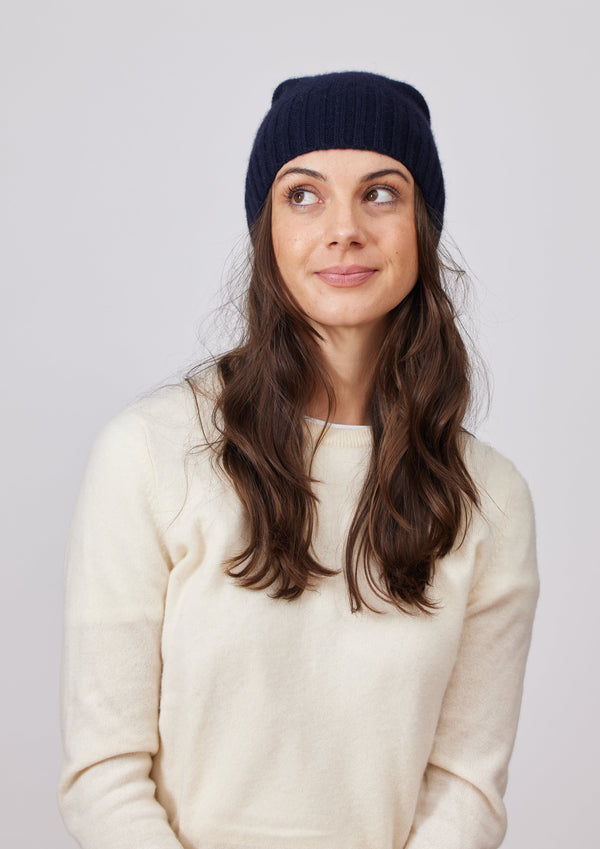 Black cashmere slouchy beanie on model wearing ivory sweater