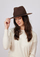 Model wearing brown wool felt hat with black tie trim detail