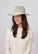 Beige wool felt hat with ivory leather trim on model