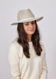 Beige brimmed wool felt hat with ivory trim on model