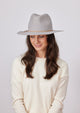 Model wearing a grey wool felt brimmed hat and cream sweater