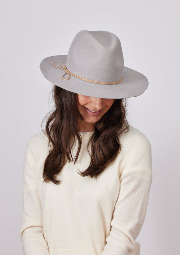 Model wearing a grey wool felt brimmed hat with tan tie detail