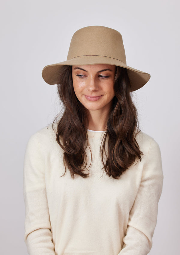 Tan velour bucket hat on model in ivory sweater