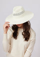 Model wearing white perforated sun hat and holding brim