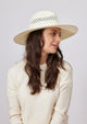 Model wearing white perforated sun hat and looking to her left