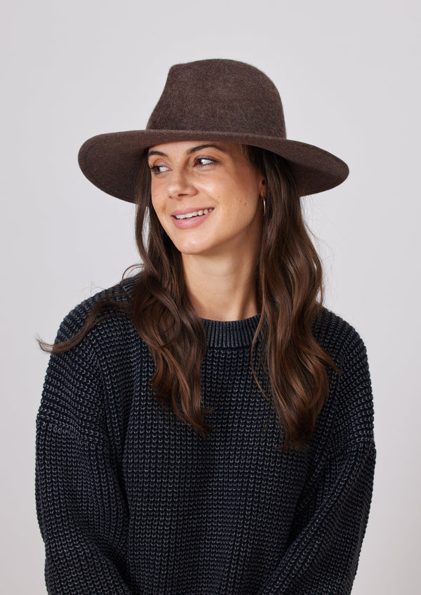 Model wearing brown velour brimmed hat and charcoal sweater 