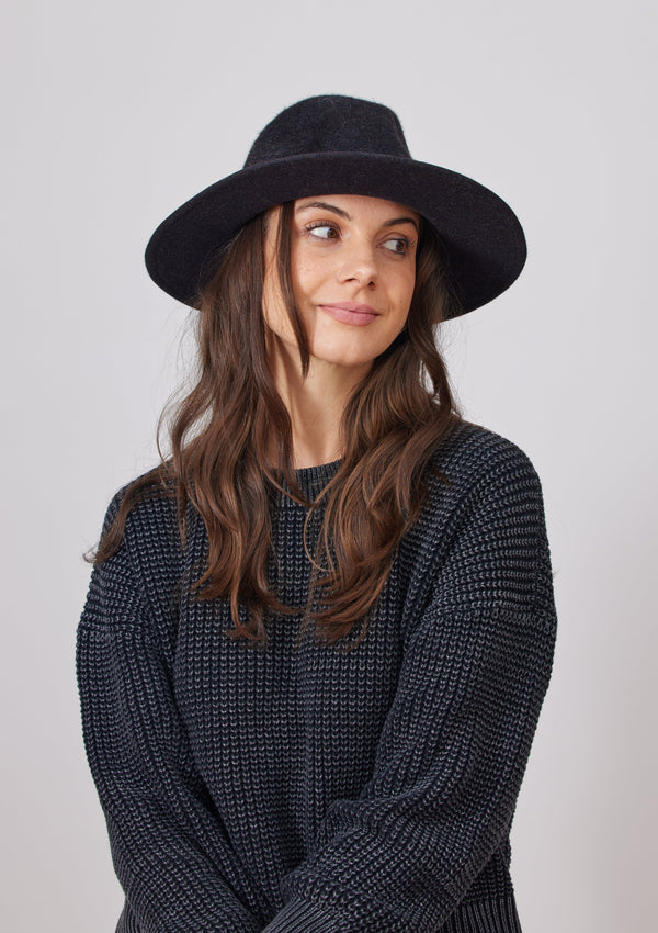 Model wearing black velour brimmed hat