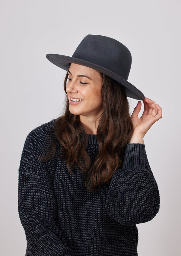 Grey wool felt brimmed hat on model wearing charcoal sweater 