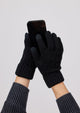 Black knit touch screen gloves on model holding cellphone