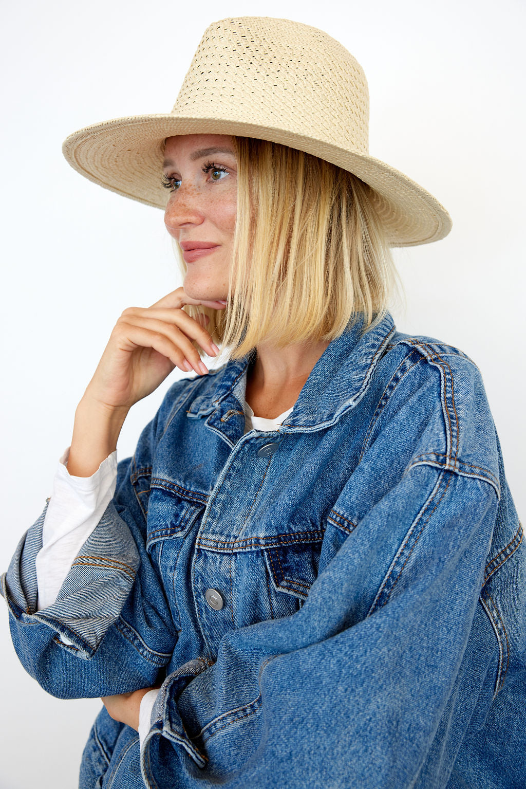 Model wearing tan perforated and vented sun hat with denim jacket