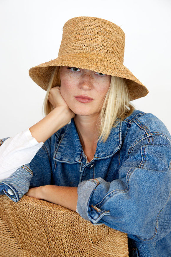 Model wearing straw bucket hat