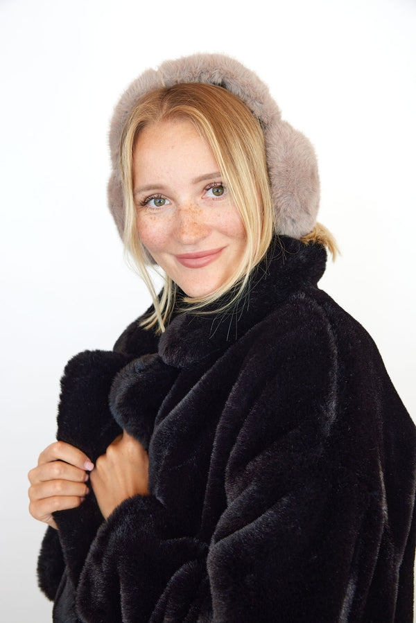 Model wearing taupe earmuffs and black coat