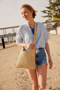 Model wearing straw crossbody bag