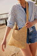 Close up of model wearing straw crossbody bag