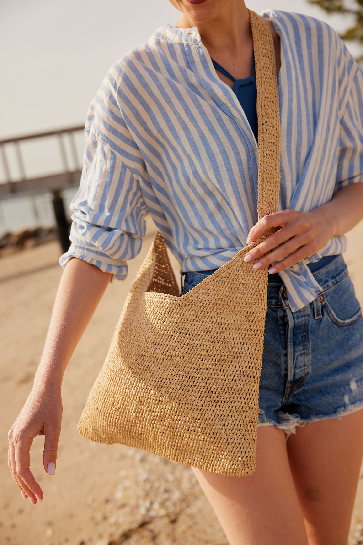 Close up of model wearing straw crossbody bag