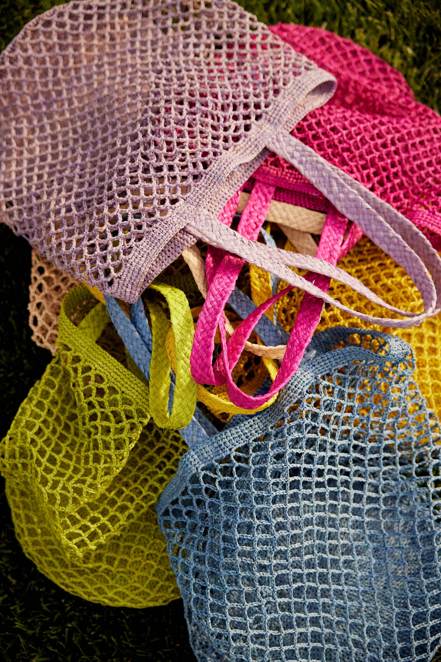 Assortment of colorful straw fisherman bags