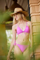 Model wearing straw hat with a colorful beaded trim