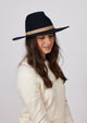 Black wool felt brimmed hat with taupe ribbon on model