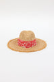 front angle of braided raffia sunhat with coral floral trim