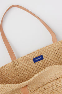Inside of raffia straw tote with leather handles