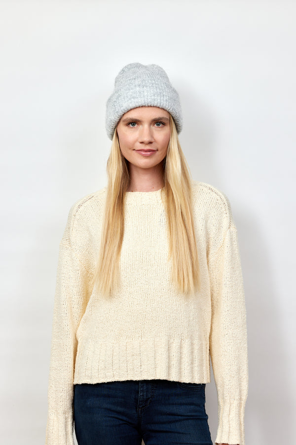 Model wearing light grey cuff beanie and ivory sweater