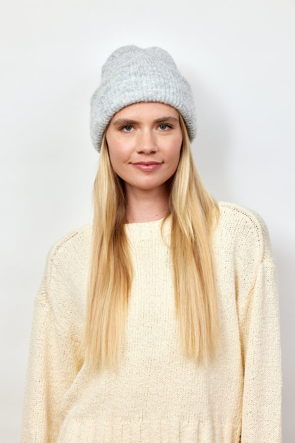 Model wearing light grey cuff beanie