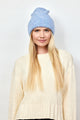 Model wearing light blue cuff beanie and ivory sweater