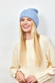 Model smiling while wearing light blue cuff beanie