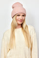 Model looking to her left and wearing light pink cuff beanie