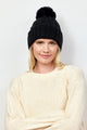 Black cable knit beanie with pom on model