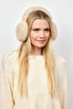 Model wearing natural colored faux fur earmuffs and ivory sweater