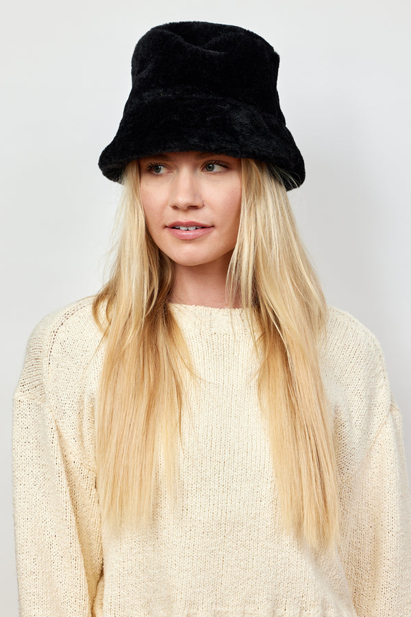 Model wearing black faux fur bucket hat